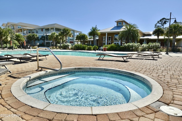 view of pool featuring a hot tub and a patio area