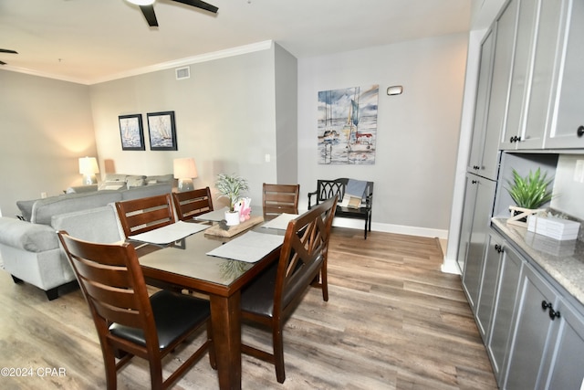 dining space with light hardwood / wood-style floors and ornamental molding