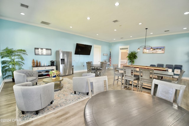 living room with crown molding and light wood-type flooring