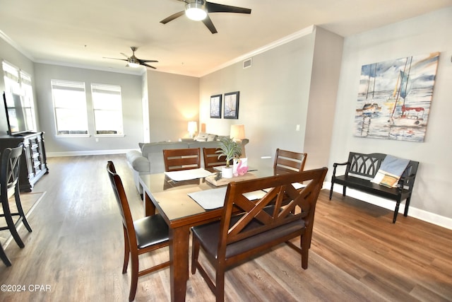 dining space featuring wood-type flooring, ceiling fan, and ornamental molding