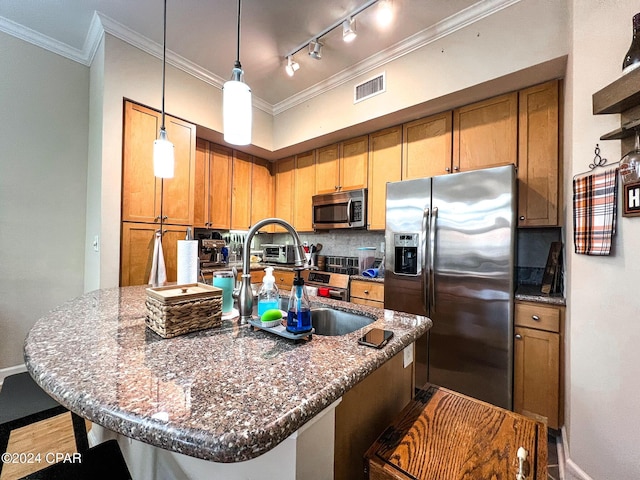 kitchen with stainless steel appliances, dark stone counters, and a center island with sink