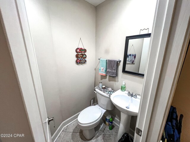 bathroom featuring sink, toilet, and tile patterned flooring