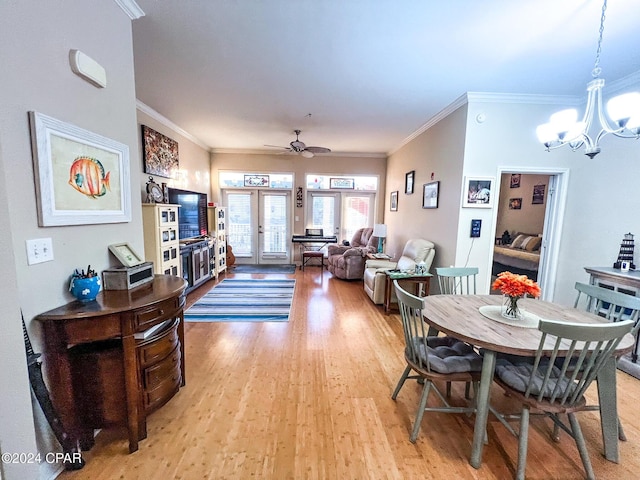 dining room featuring french doors, crown molding, ceiling fan with notable chandelier, and light wood-type flooring