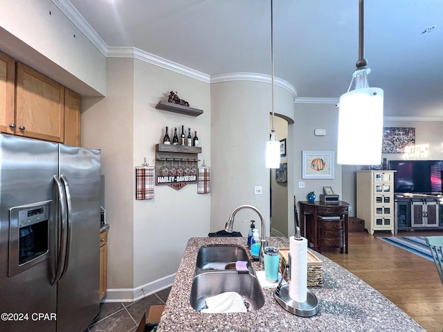 kitchen with sink, crown molding, stainless steel fridge, and decorative light fixtures