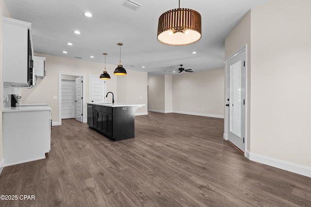 kitchen featuring sink, hanging light fixtures, an island with sink, white cabinets, and dark hardwood / wood-style flooring