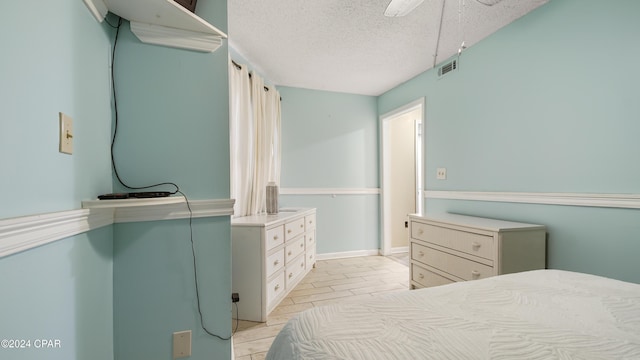 bedroom with ceiling fan and a textured ceiling