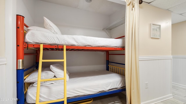 bedroom featuring a drop ceiling and hardwood / wood-style flooring