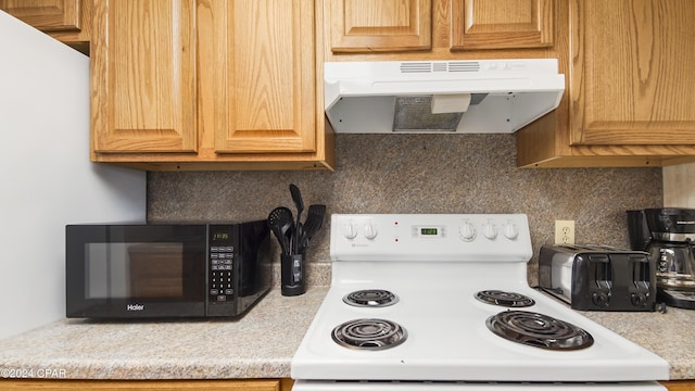 kitchen with white electric stove and tasteful backsplash