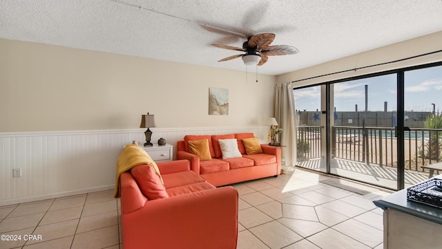 tiled living room featuring ceiling fan and a textured ceiling