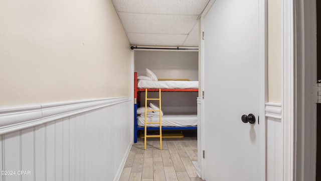 interior space featuring a paneled ceiling and light hardwood / wood-style flooring