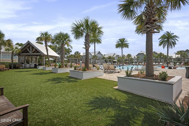 view of property's community featuring a gazebo, a swimming pool, a lawn, and a patio