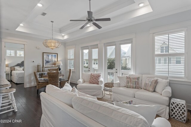 dining area featuring a raised ceiling, ceiling fan, dark wood-type flooring, and ornamental molding