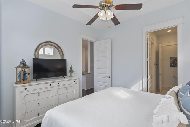 living room featuring ceiling fan with notable chandelier, a tray ceiling, crown molding, and dark wood-type flooring