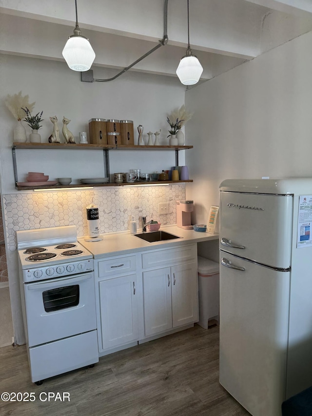 kitchen featuring pendant lighting, white fridge, range, and sink