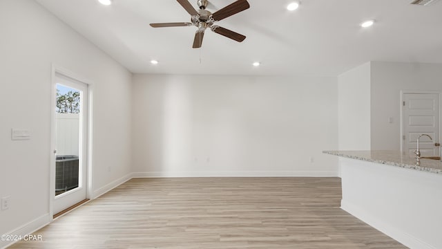 interior space with ceiling fan, light hardwood / wood-style flooring, and sink