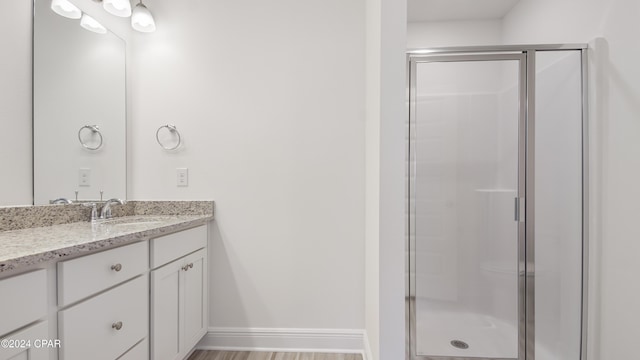 bathroom featuring hardwood / wood-style floors, vanity, and an enclosed shower