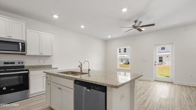 kitchen with sink, appliances with stainless steel finishes, a center island with sink, white cabinets, and light wood-type flooring