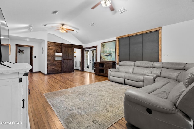 living room with ceiling fan, lofted ceiling, and light hardwood / wood-style flooring