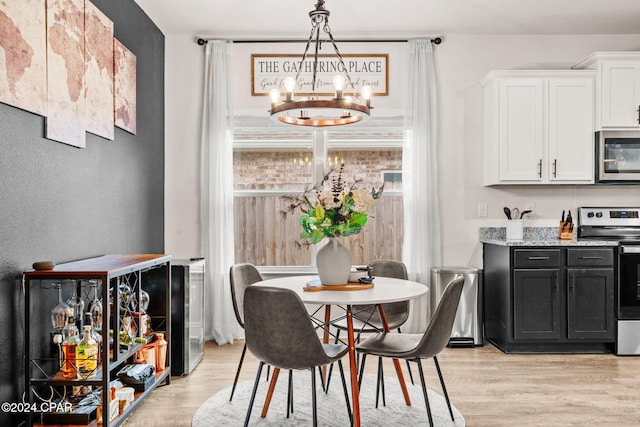 dining room with light hardwood / wood-style flooring and an inviting chandelier