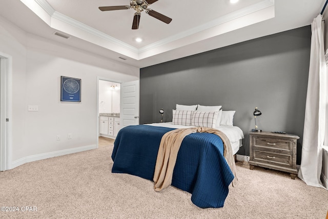 bedroom with a raised ceiling, ensuite bath, ceiling fan, and ornamental molding