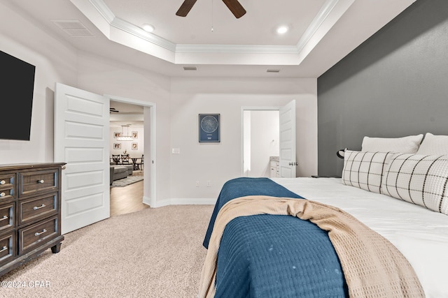 bedroom with ceiling fan, ornamental molding, light carpet, and a tray ceiling