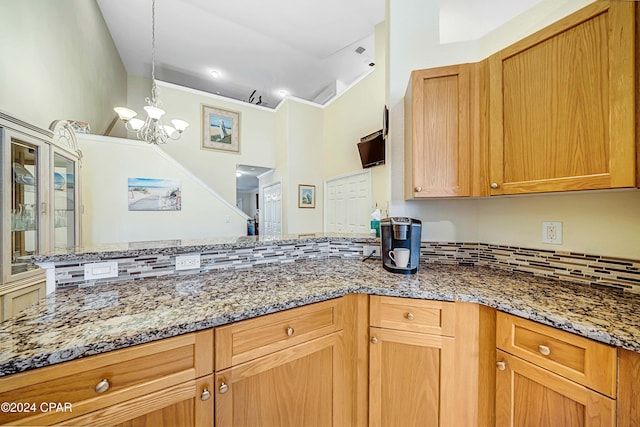 kitchen featuring stone countertops, tasteful backsplash, and a notable chandelier