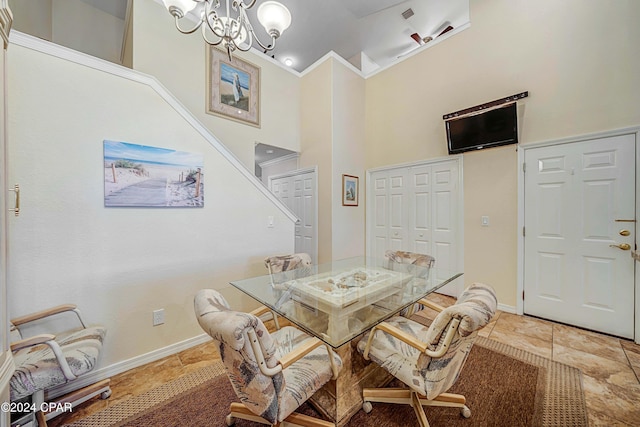 dining room featuring ceiling fan with notable chandelier, ornamental molding, and a high ceiling