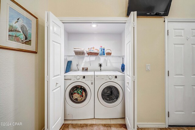 washroom featuring washing machine and dryer and light tile patterned flooring