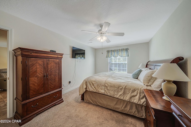 carpeted bedroom featuring a textured ceiling and ceiling fan