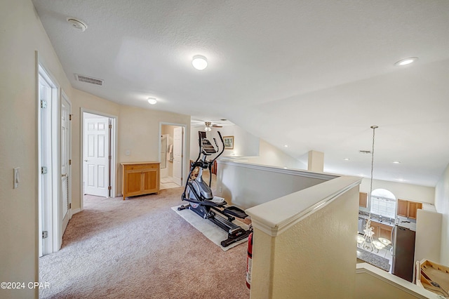 workout room with light carpet, a textured ceiling, vaulted ceiling, and ceiling fan