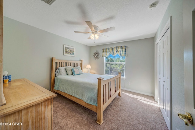 carpeted bedroom featuring a textured ceiling, a closet, and ceiling fan