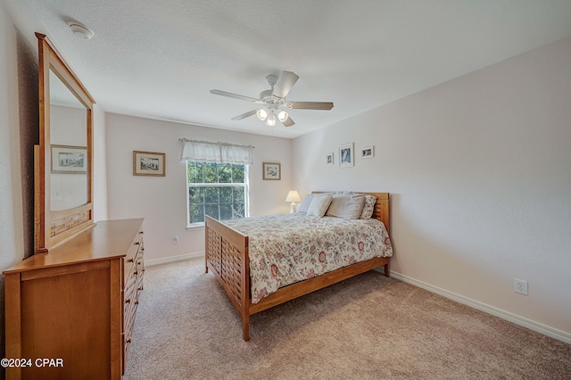 carpeted bedroom featuring a textured ceiling and ceiling fan