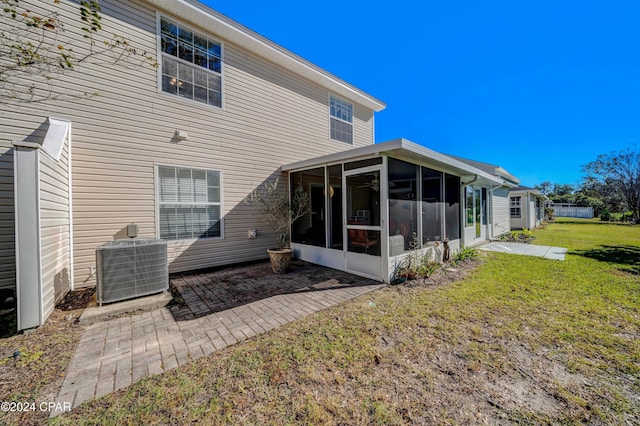 back of property with a sunroom, cooling unit, a yard, and a patio