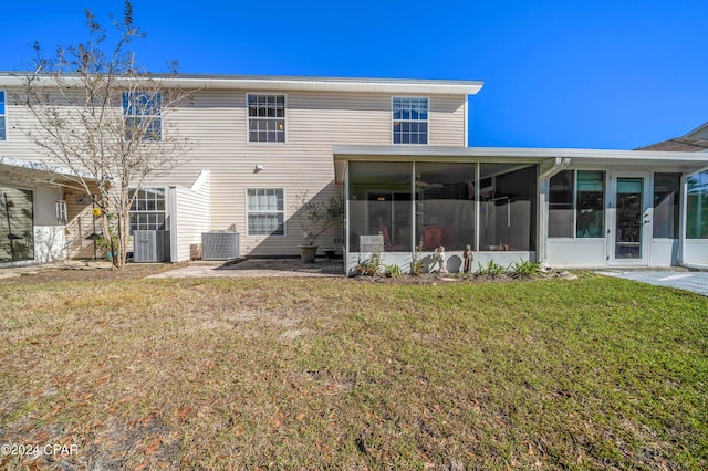 back of house featuring a sunroom, a yard, and central AC