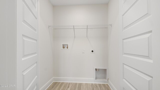 clothes washing area featuring hookup for an electric dryer, light hardwood / wood-style flooring, and washer hookup