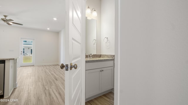 bathroom with wood-type flooring, vanity, and ceiling fan