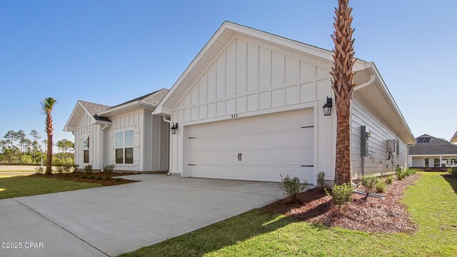 view of front of home with roof with shingles, concrete driveway, a front lawn, a garage, and board and batten siding