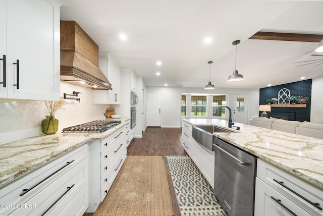 kitchen with white cabinetry, sink, dark hardwood / wood-style floors, custom range hood, and appliances with stainless steel finishes