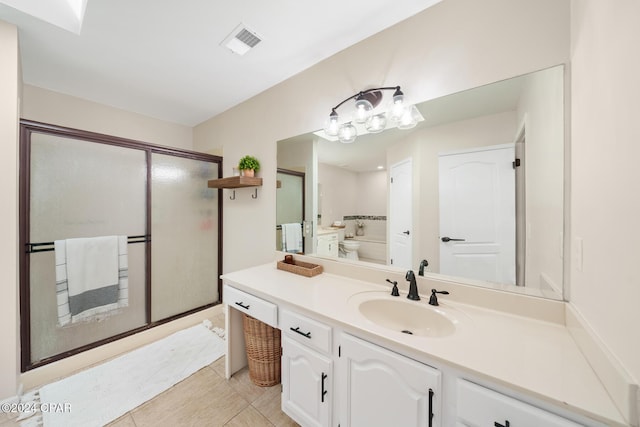 bathroom with tile patterned flooring, vanity, a shower with shower door, and toilet