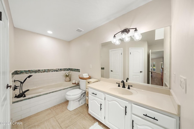 bathroom with tile patterned flooring, vanity, tiled bath, and toilet