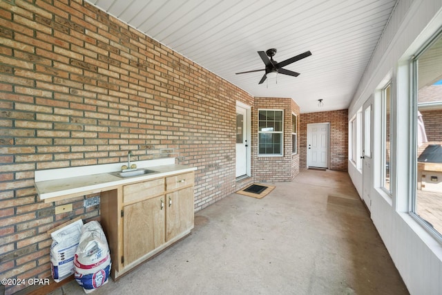 unfurnished sunroom featuring ceiling fan and sink