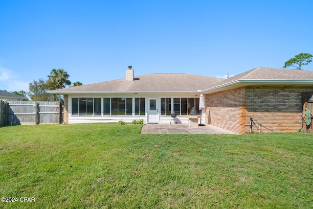 back of house with a patio area and a lawn