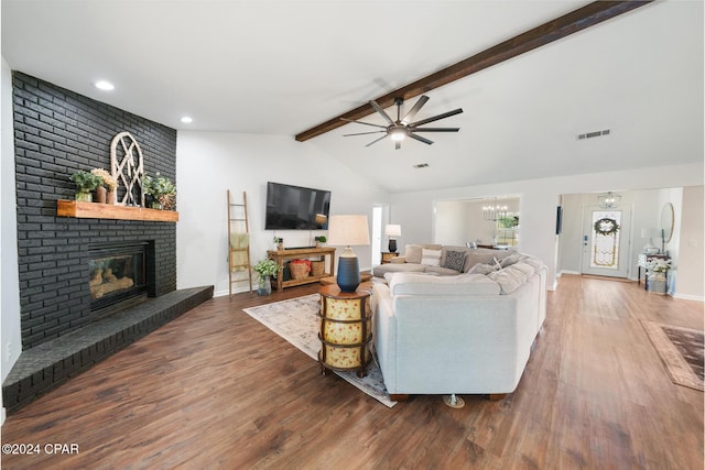 living room with a fireplace, vaulted ceiling with beams, dark hardwood / wood-style floors, and ceiling fan with notable chandelier