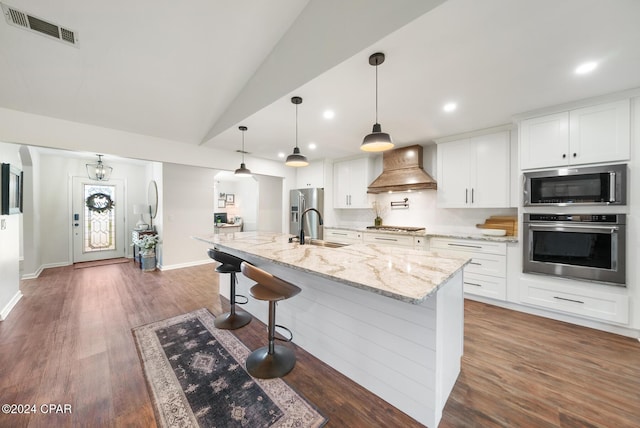 kitchen with white cabinets, premium range hood, and appliances with stainless steel finishes