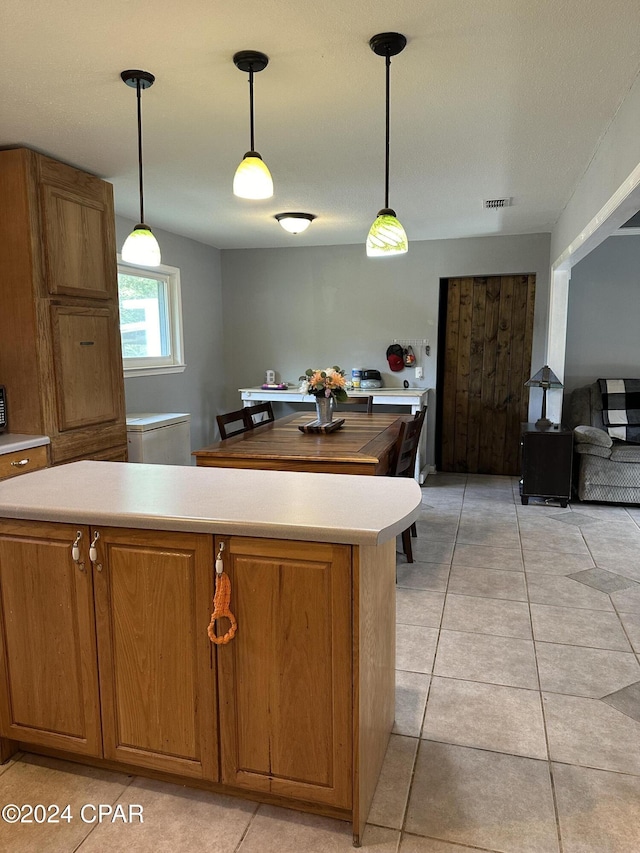 kitchen featuring light tile patterned floors and hanging light fixtures