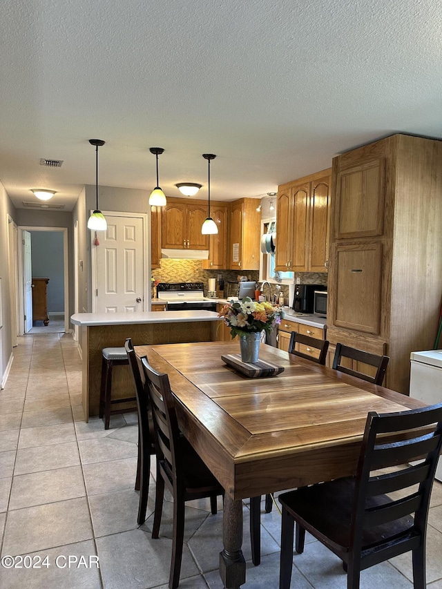 dining room with light tile patterned floors and a textured ceiling