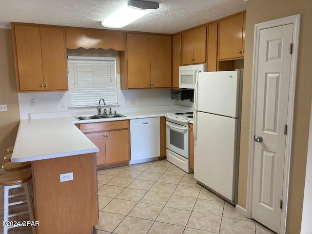 kitchen with sink, kitchen peninsula, a textured ceiling, white appliances, and light tile patterned flooring