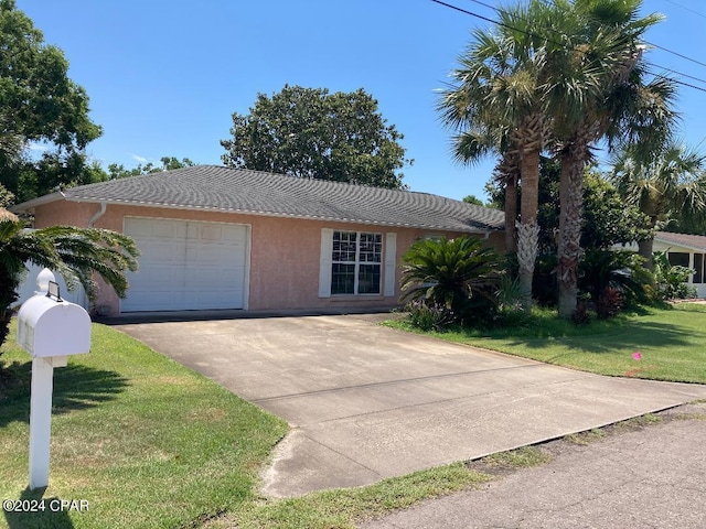 single story home featuring a front lawn and a garage