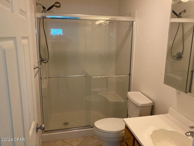 bathroom featuring tile patterned floors, vanity, toilet, and a shower with shower door