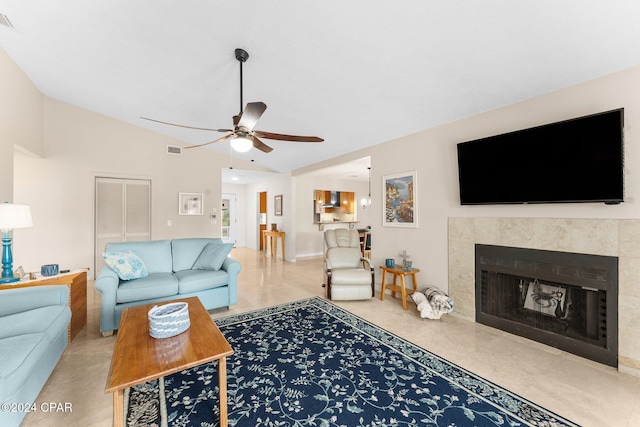 living room with a fireplace, vaulted ceiling, and ceiling fan